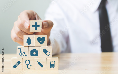 Hand arranging wood block stacking with icon healthcare medical, Insurance for your health concept photo
