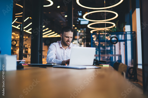 Focused young man using laptop in workspace