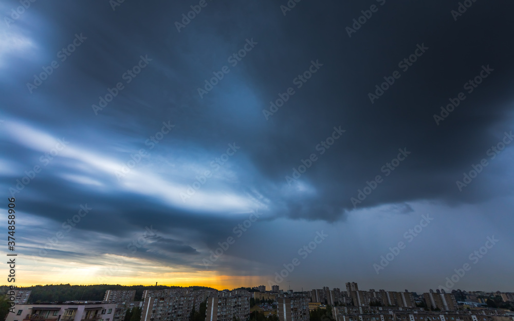 Storm clouds over the city with rain shaft