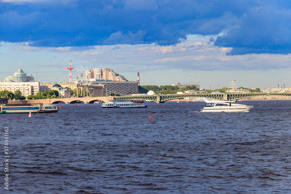 White yacht and tourist boats sailing on the Neva river in St. Petersburg, Russia