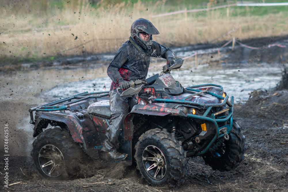 Active ATV and UTV riding in the mud and water at sunny day