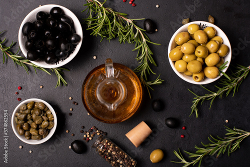 olive oil in a glass bottle with olives, herbs and spices