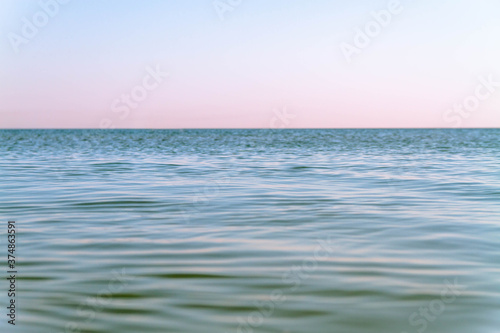 Blue calm sea. Seascape. A smooth sea without waves. The ocean in the late evening.