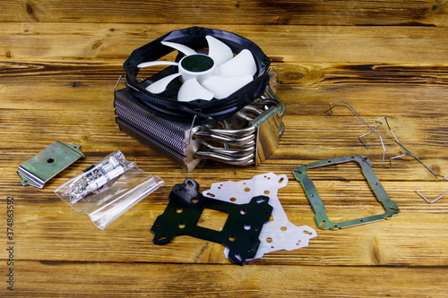 Modern CPU cooler with installation kit on a wooden desk photo