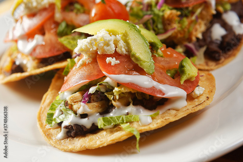 Chicken tostadas with beans, lettuce, tomato, fresh cheese and avocado.