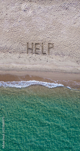 Help written on exotic sand beach with tropic blue sea. 