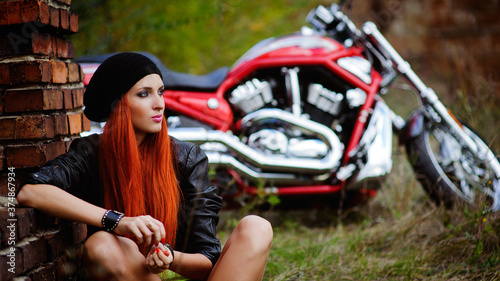 red-haired beautiful girl and motorcycle outdoors