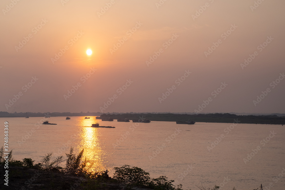 Naklejka premium Sunset over the red river with boats in hanoi