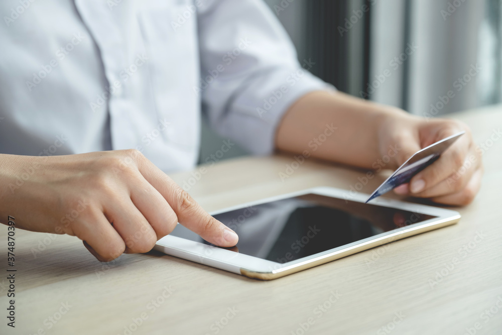Businessman hand use tablet and hold credit card to online shopping from home, payment e-commerce, internet banking, spending money for next holidays Businessman hand use tablet and hold credit card to online shopping from home, payment e-commerce, internet banking, spending money for next holidays