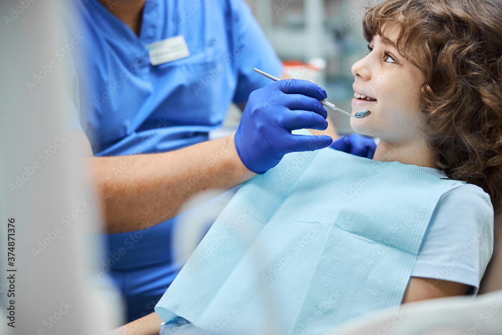 Fototapeta premium Cheerful kid smiling during a dental check-up