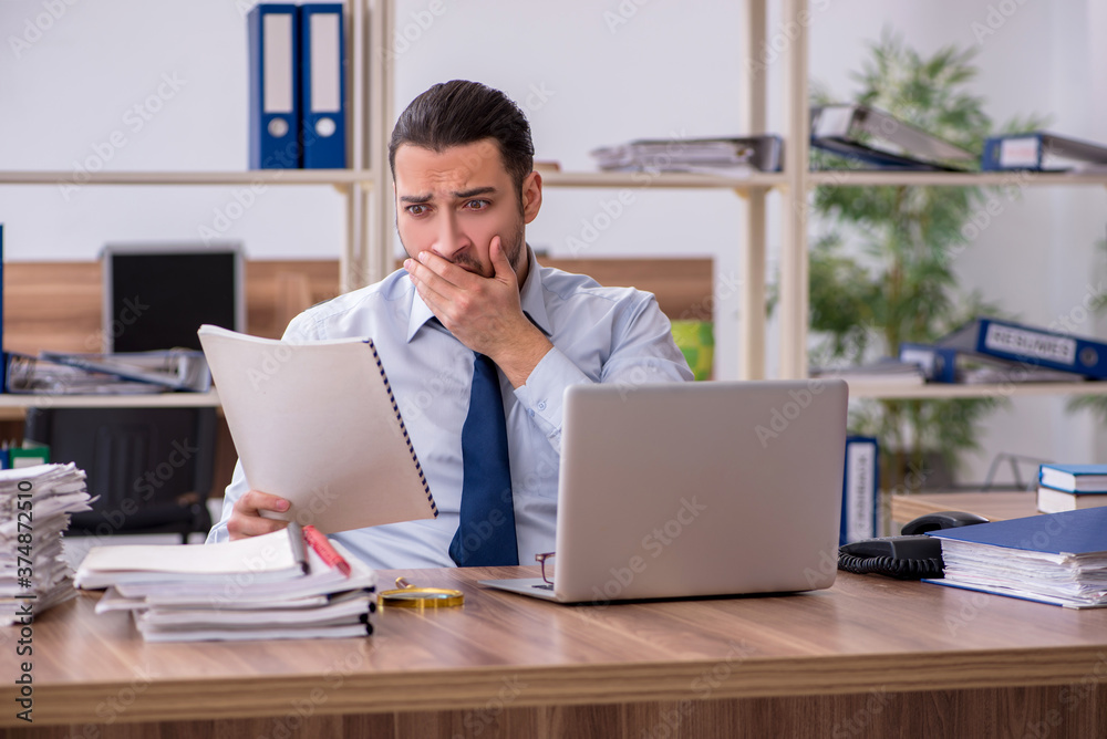 Young male employee unhappy with excessive work Young male employee unhappy with excessive work