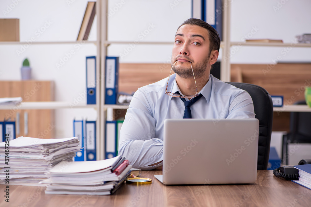 Young male employee unhappy with excessive work Young male employee unhappy with excessive work