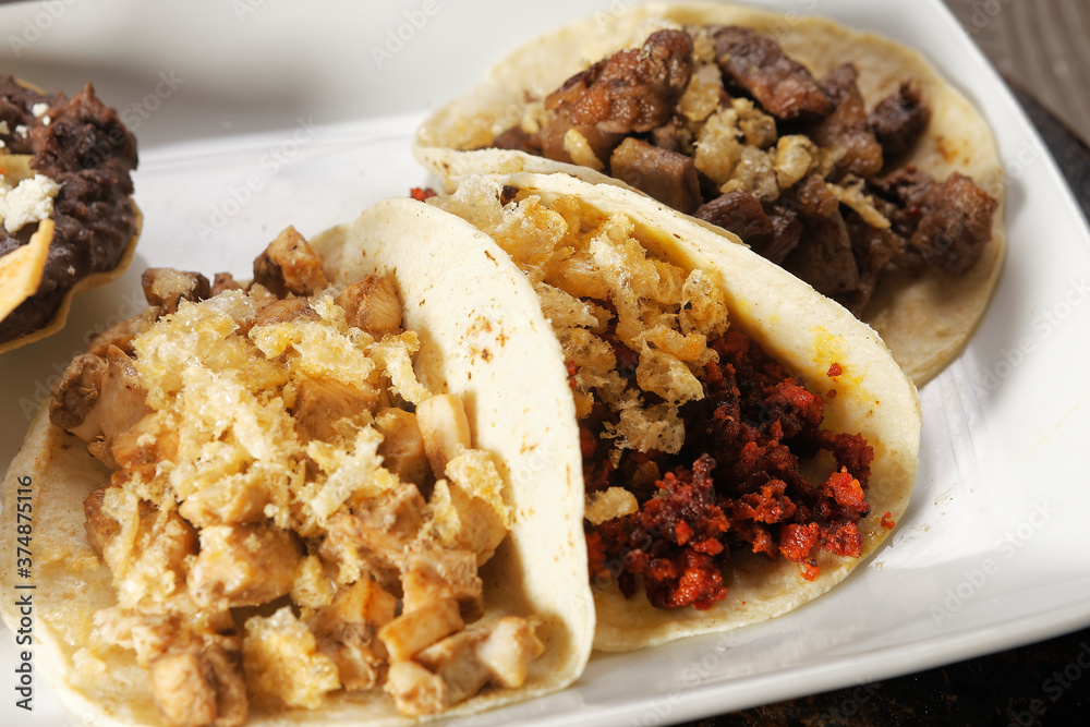 Roast beef tacos, roasted chicken and chorizo with pork rinds accompanied with refried beans and spicy sauce. Roast beef tacos, roasted chicken and chorizo with pork rinds accompanied with refried beans and spicy sauce.