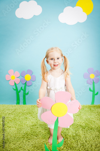 Happy Little Girl Holding a Flower in Imaginary Outside Wonderland World