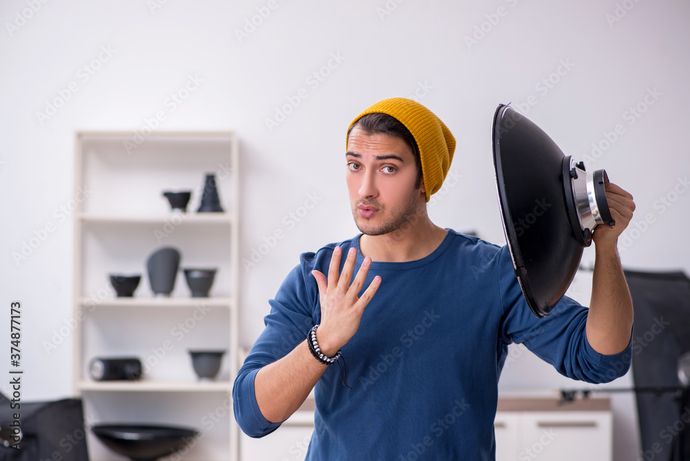 Young male photographer working in the studio Young male photographer working in the studio