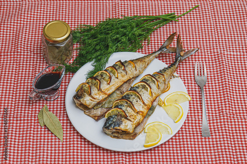 Baked mackerel or scomber fish served on table photo