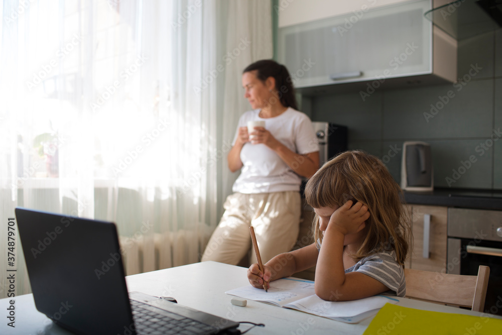 schoolgirl doing his homework with laptop at home. homeschooling, distant learning schoolgirl doing his homework with laptop at home. homeschooling, distant learning