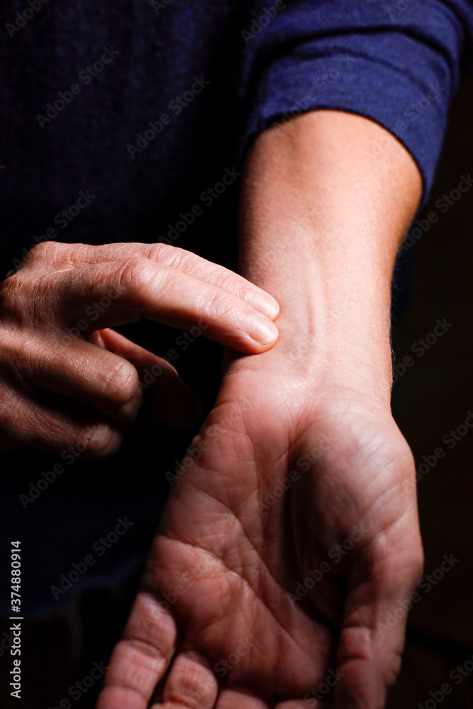 A woman checks her pulse with her fingers