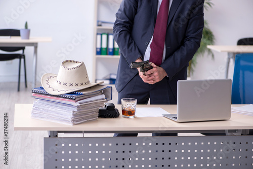 Funny old boss in cowboy hat in the office