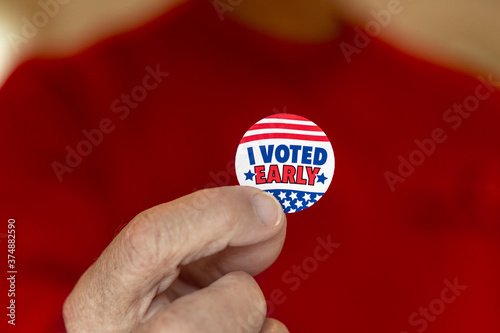 Close up of older man holding I voted early sticker