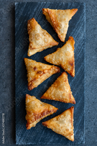 Fried Samosa (samoosa) triangle pastries on a dark surface