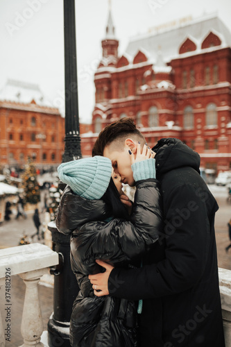 Young passionate couple kissing gently on Christmas street. Young couple kissing and hugging outdoor.