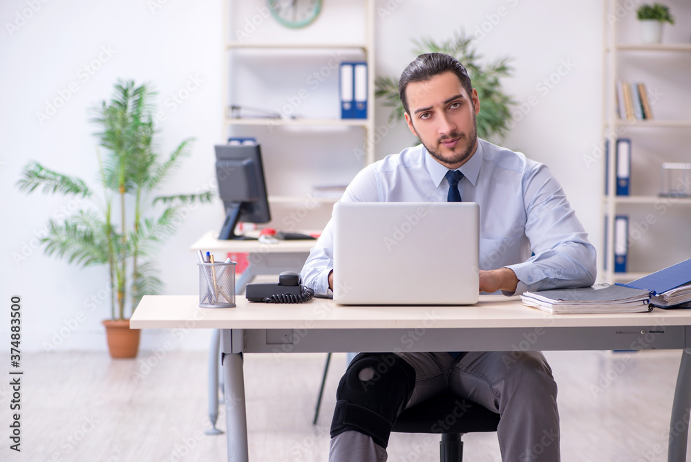 Young leg injured employee working in the office