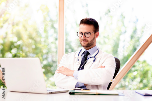 Thinking male doctor sitting in the doctor's office