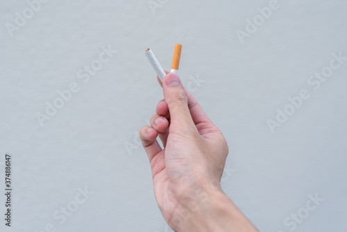 Stop smoking and Quit smoking cigarettes concept. Portrait of beautiful  girl holding broken cigarette in hands. Happy female quitting smoking cigarettes. Quit bad habit, health care concept.