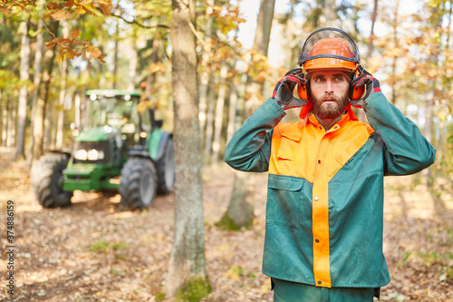 Forest worker with safety helmet and ear protection