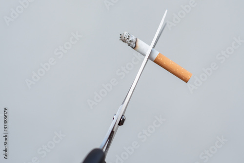 Man cuts a cigarette with scissors and Quit smoking.