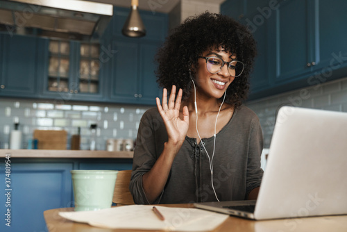 Attractive smiling young african woman on a video call photo