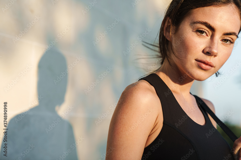 Image of young athletic sportswoman posing and looking at camera