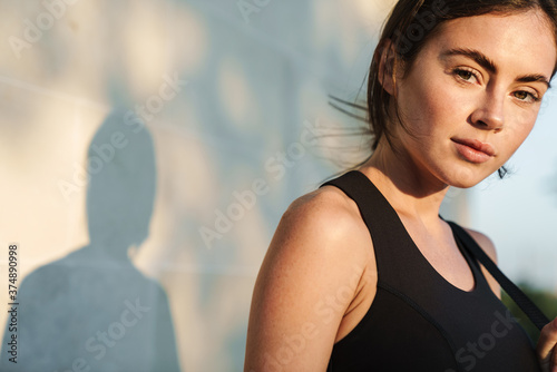 Image of young athletic sportswoman posing and looking at camera
