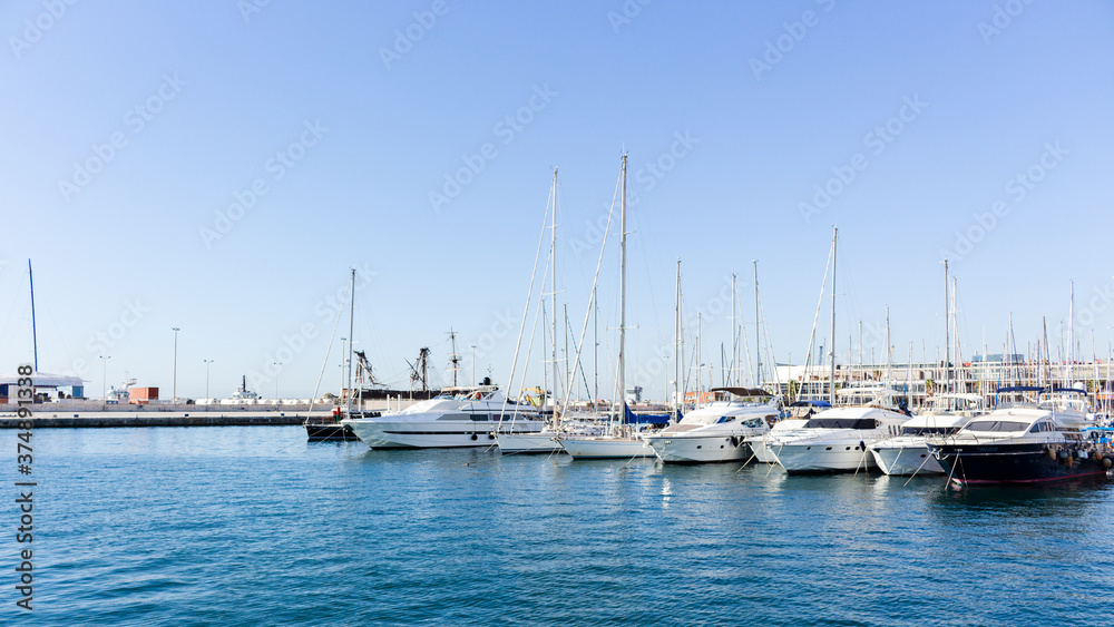 Landscape of the port of alicante with the sea with many boats with a clear blue sky in alicante, spain