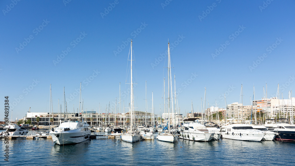 Landscape of the port of alicante with the sea with many boats with a clear blue sky in alicante, spain