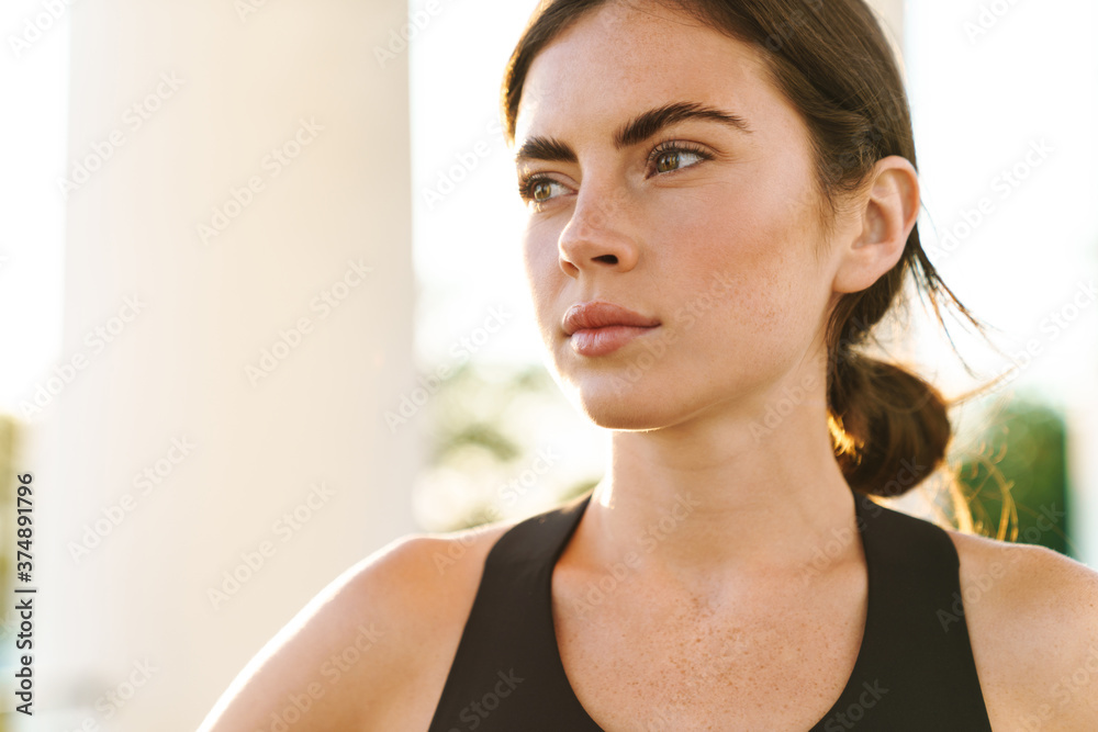 Image of caucasian serious sportswoman looking aside while working out Image of caucasian serious sportswoman looking aside while working out