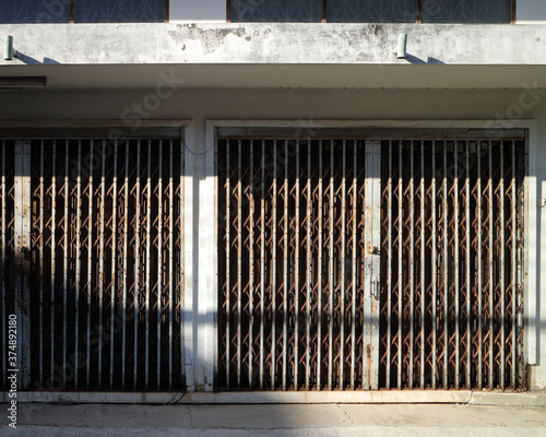 iron door in old shophouse with light and shadow, background for text or image
 photo