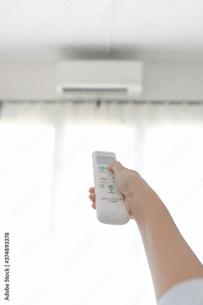 The housekeeper is using the air conditioner by selecting the image focus on the remote. The housekeeper is using the air conditioner by selecting the image focus on the remote.