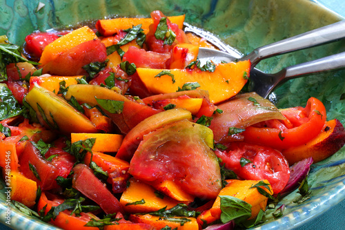 Foto Bowl of fresh peach, tomato and basil salad