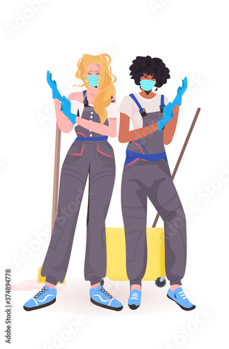 women janitors professional office cleaners in medical masks wearing gloves coronavirus quarantine concept full length vertical vector illustration