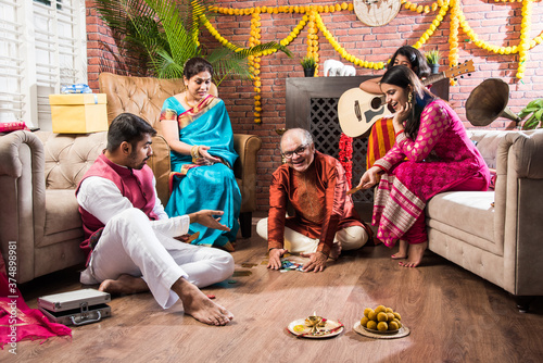 Indian family playing Three Cards or Teen Patti in Diwali or Deepavali festival at home photo