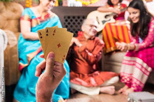 Indian family playing Three Cards or Teen Patti in Diwali or Deepavali festival at home photo