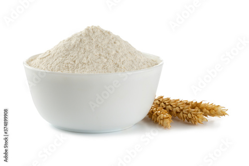 Bowl with flour on white background. spikelets of wheat