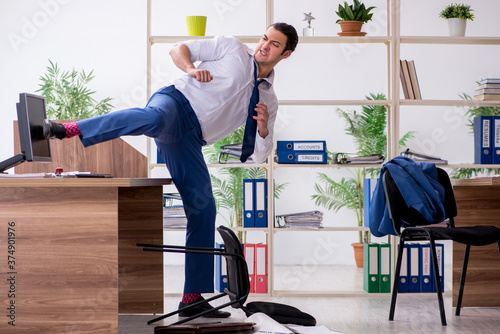 Canvas Print Young male employee businessman at workplace