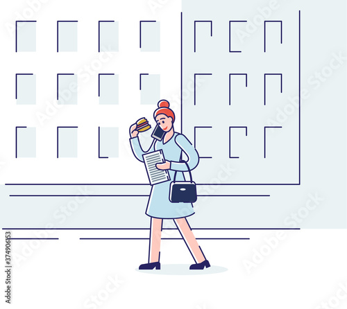Woman eating sandwich and talking on phone while walking street in morning