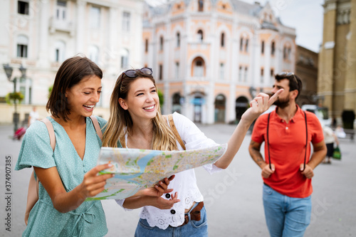 Happy traveling tourists sightseeing with map and having fun