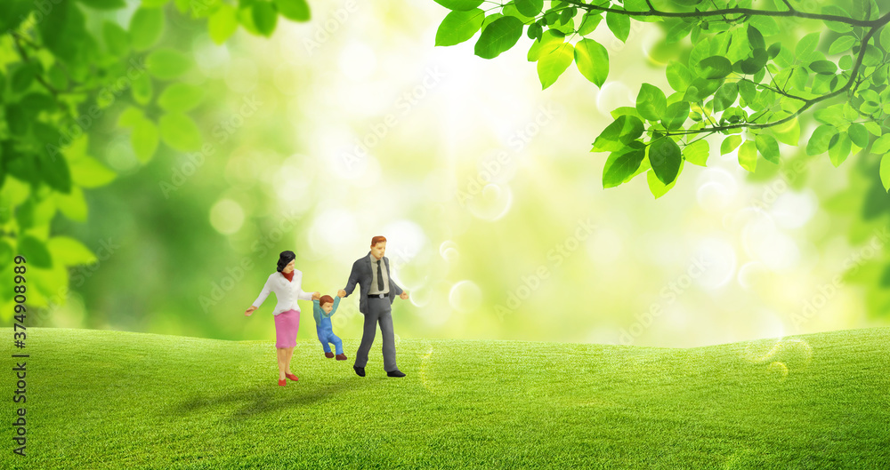 Happy Family Concept : Miniature people as happiness family walking on green grass meadow field with green natural and sunlight in background. Happy Family Concept : Miniature people as happiness family walking on green grass meadow field with green natural and sunlight in background.