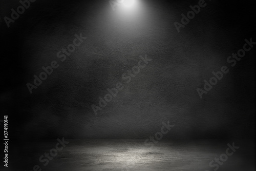 Empty space studio dark room of Concrete floor with spot lighting and smoke in black background.