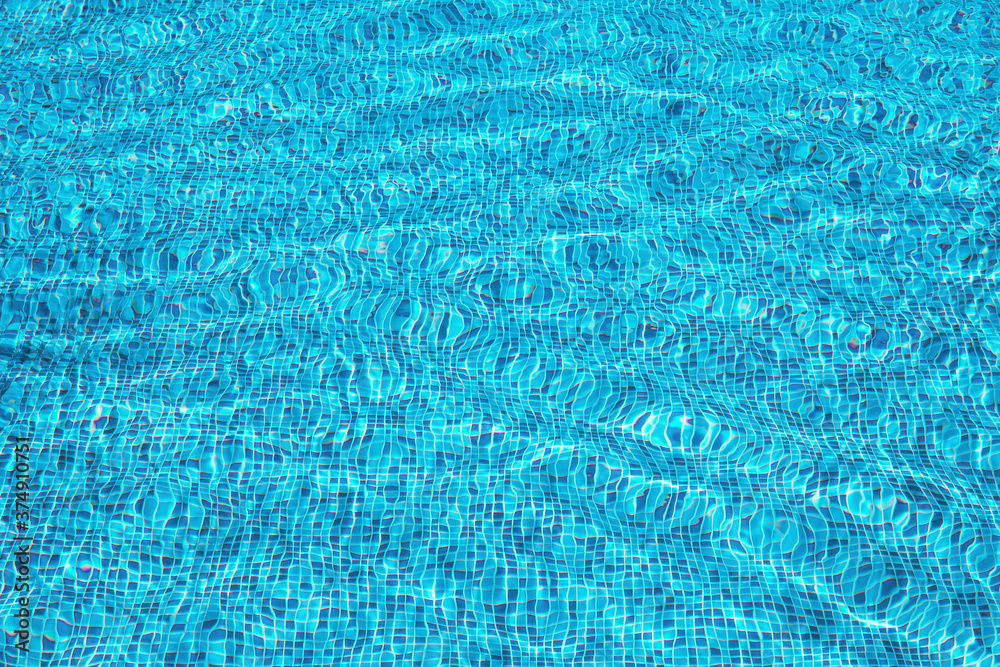 Abstract summer background of blue water surface in swimming pool.